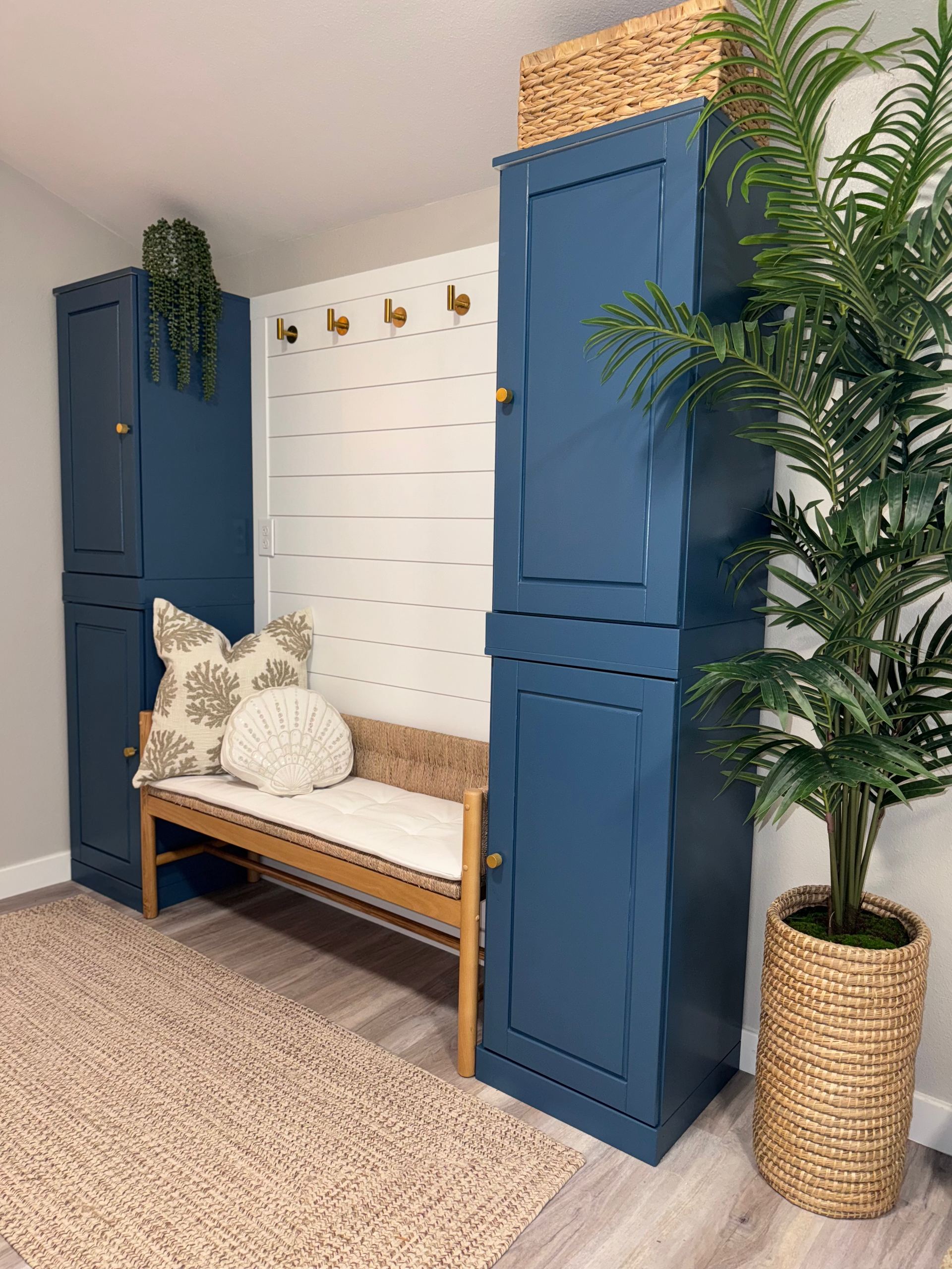 Entryway with navy built-in cabinets, shiplap wall and woven bench